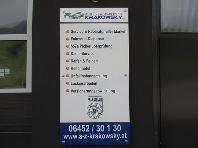 Tafel am Eingang mit der Leistungsliste, dem Prüfstellen-Zeichen und der Telefonnummer