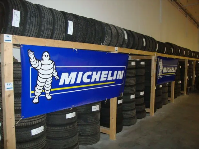 Reifenlager mit Holzregalen voller eingelagerter Reifen und einem Michelin-Banner