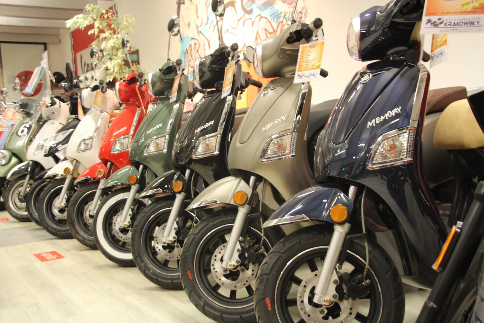 Lange Reihe Vespa-Roller nebeneinander im Schauraum